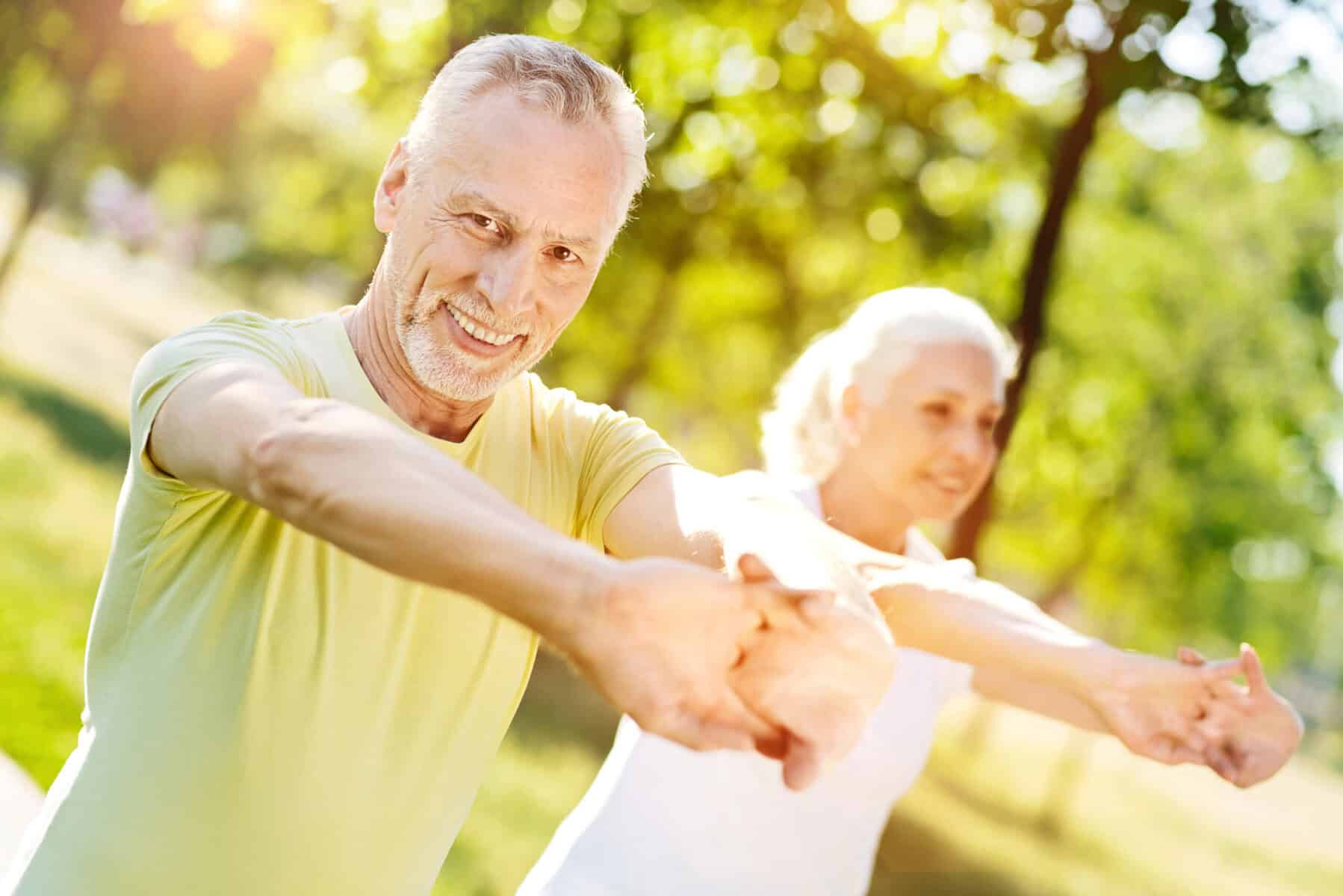 Depositphotos_159440528_XL (1) Elderly couple exercising outdoors in park during sunny day.