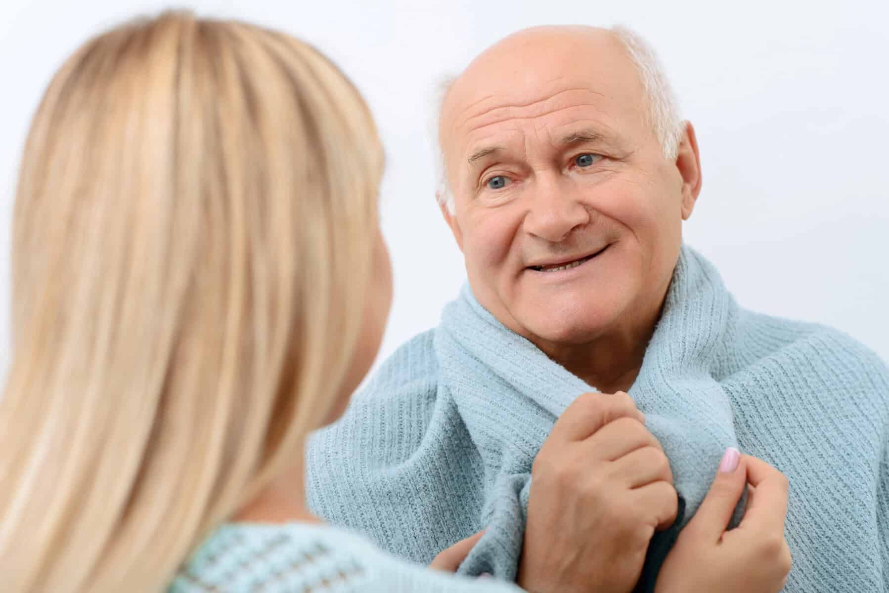 Senior man smiling during consultation with a healthcare professional.
