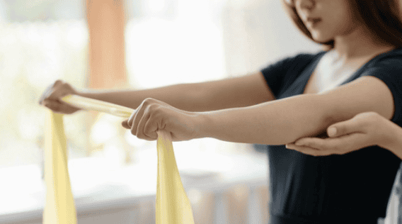 Stretching therapy with resistance bands at Infinite Medical clinic in St. George, Utah Woman performing resistance band stretch for physical therapy.